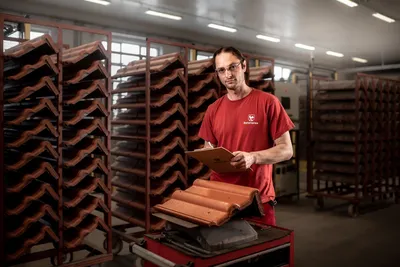 Muž držící střešní tašky